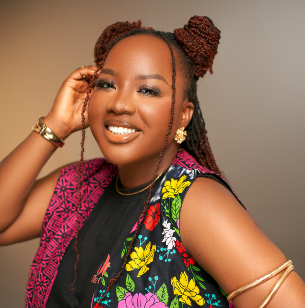 Professional portrait of Nigerian singer-songwriter and international award-winning artist Blessing Tangban, smiling while wearing a vibrant floral patterned vest