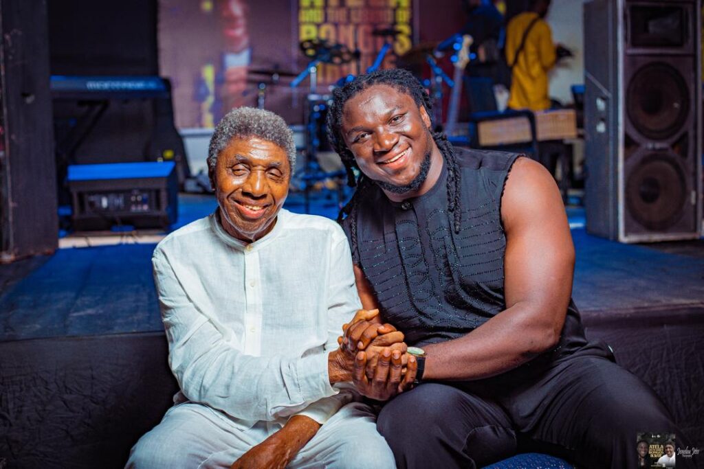 Nigerian folk singer Francis Atela smiling and holding hands with legendary music icon Bongos Ikwue